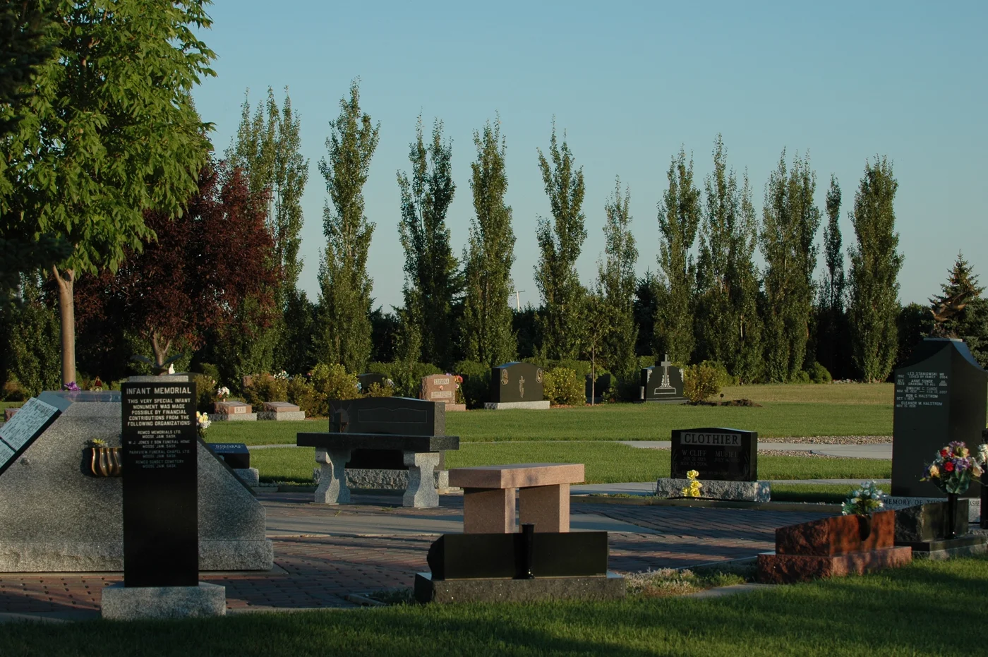 Memorial benches and stone structures in a green garden setting.